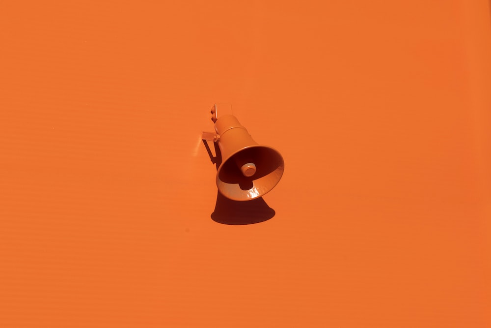 An Orange Megaphone Against an Orange Backdrop, Symbolizing the Universality of Mass Notification Systems